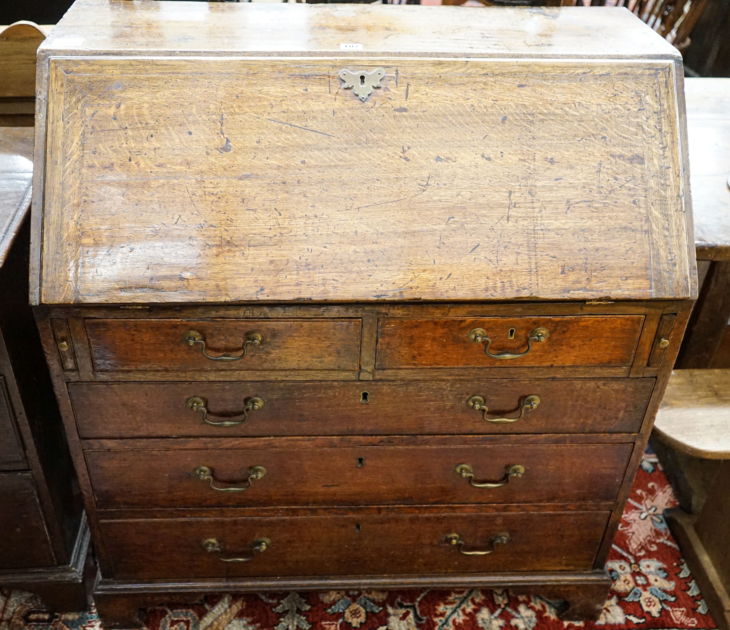 A George III oak bureau, with fitted interior, two short and three long drawers, width 92cm, depth 50cm, height 100cm